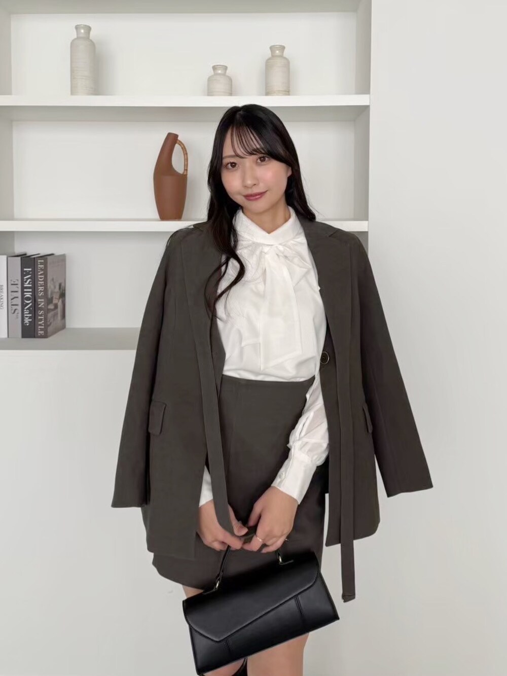 ブラウン系のスカート、ホワイト系のシャツ/ブラウス、ブラウン系のテーラードジャケットを着用したレディースの冬コーディネートの3枚目の写真