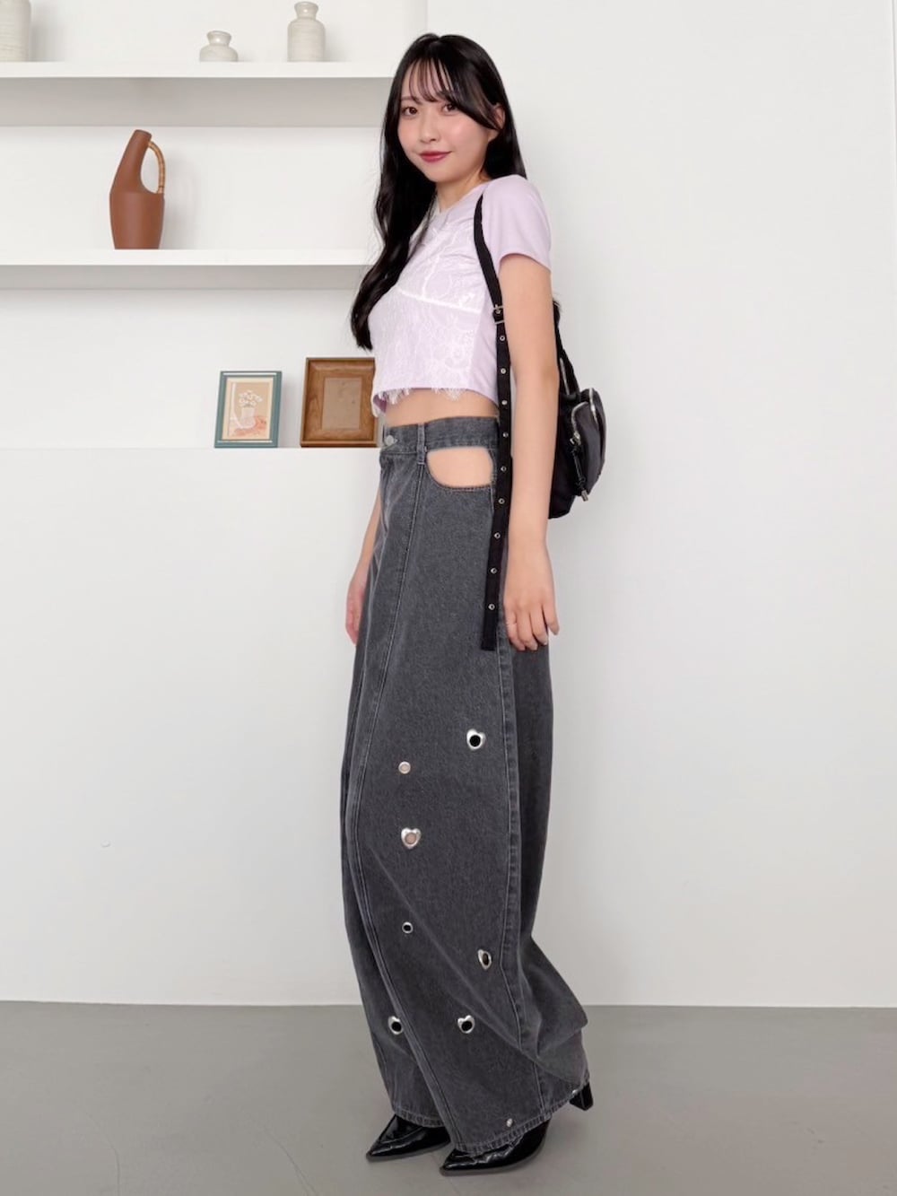 パープル系のTシャツ/カットソー、グレー系のデニムパンツを着用したレディースの冬コーディネートの2枚目の写真