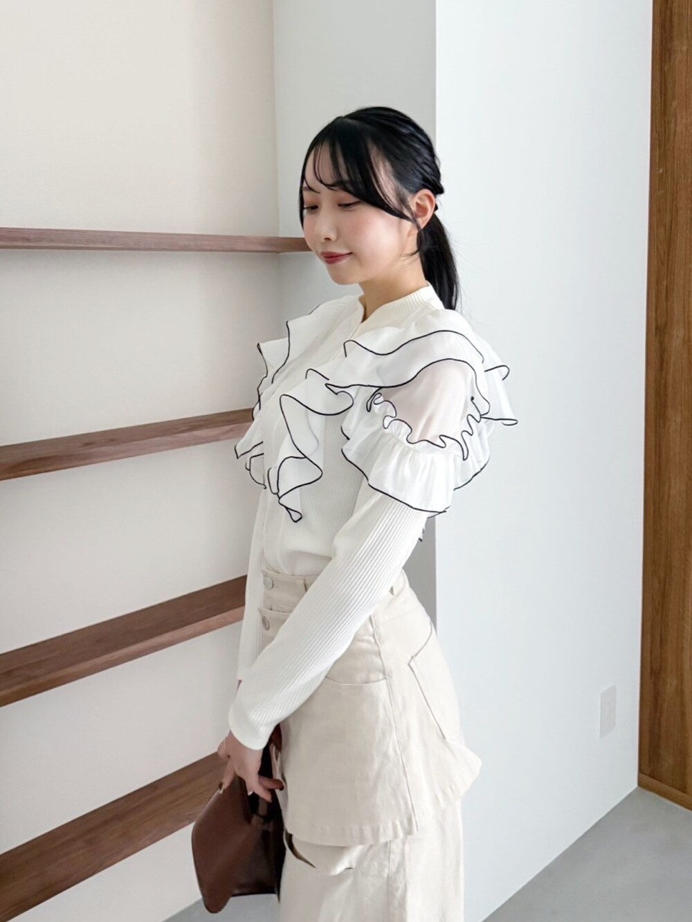 ベージュ系のデニムパンツ、ホワイト系のTシャツ/カットソーを着用したレディースの冬コーディネートの5枚目の写真