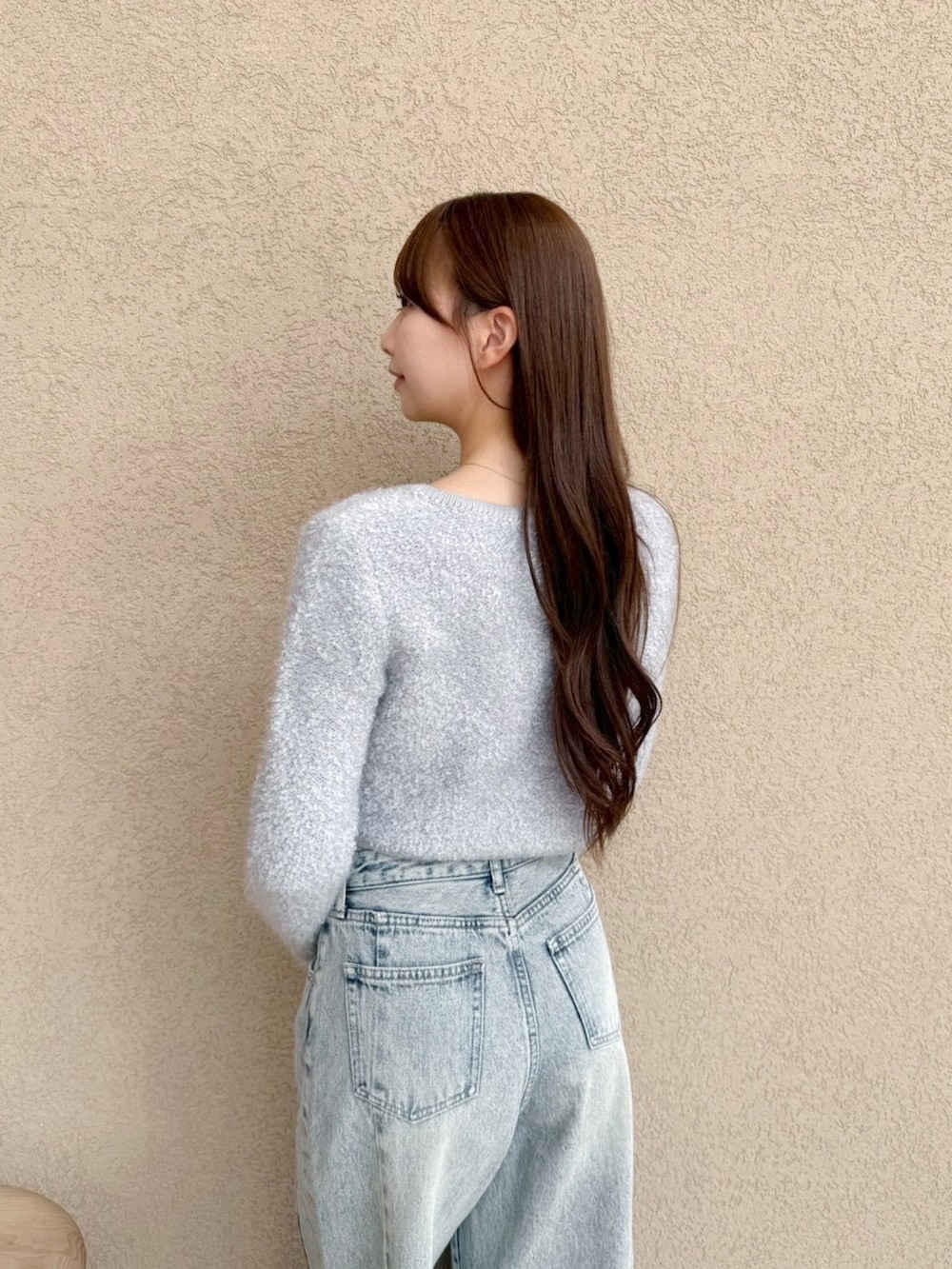 ブルー系のデニムパンツ、グレー系のノーカラージャケットを着用したレディースの秋コーディネートの5枚目の写真