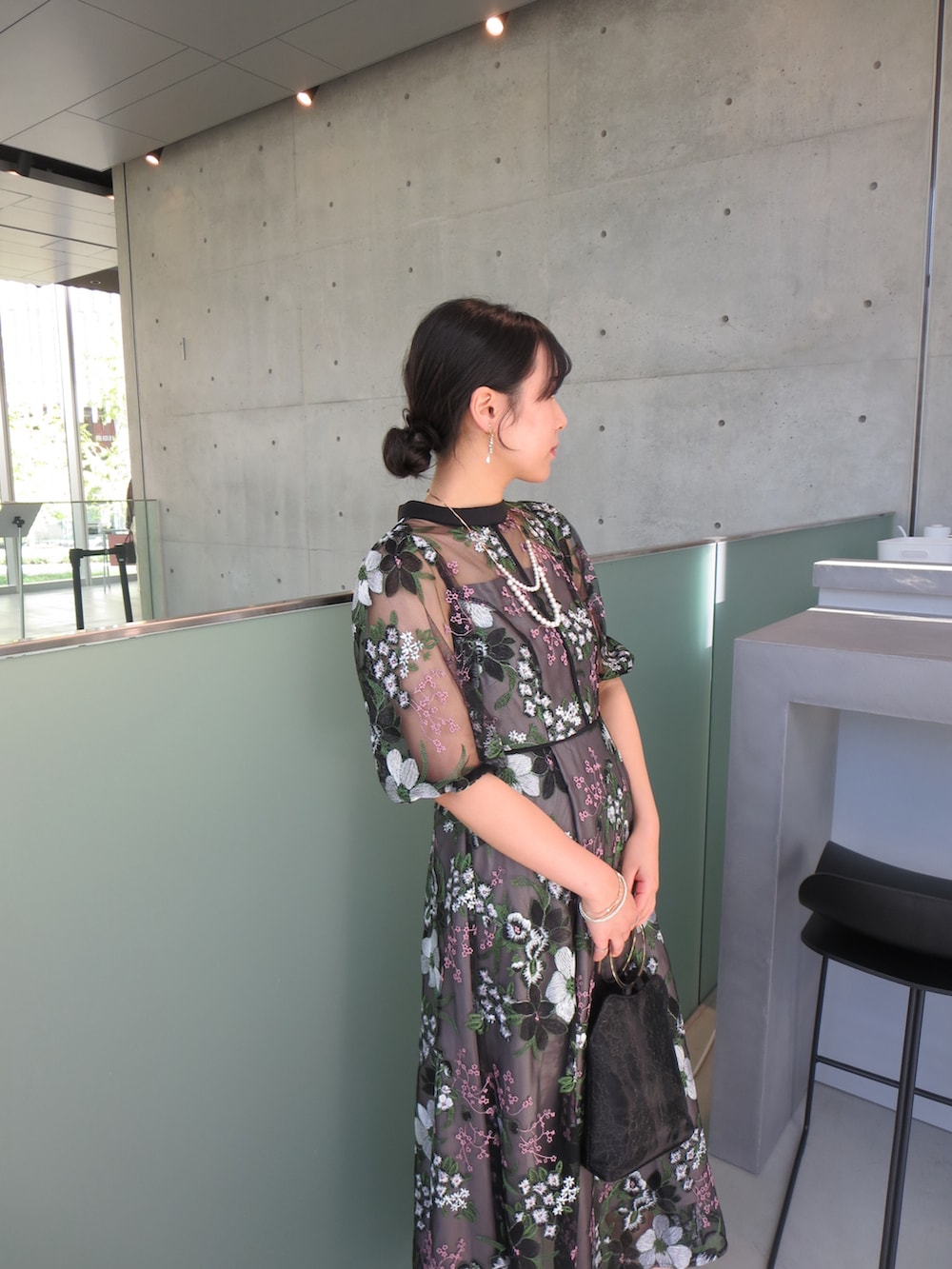 ベージュ系のハンドバッグ、ブラック系のドレス、ベージュ系のパンプスを着用したレディースの秋コーディネートの2枚目の写真