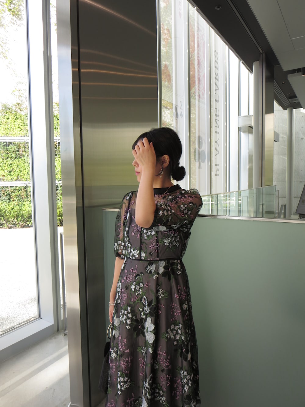 ベージュ系のハンドバッグ、ブラック系のドレス、ベージュ系のパンプスを着用したレディースの秋コーディネートの4枚目の写真