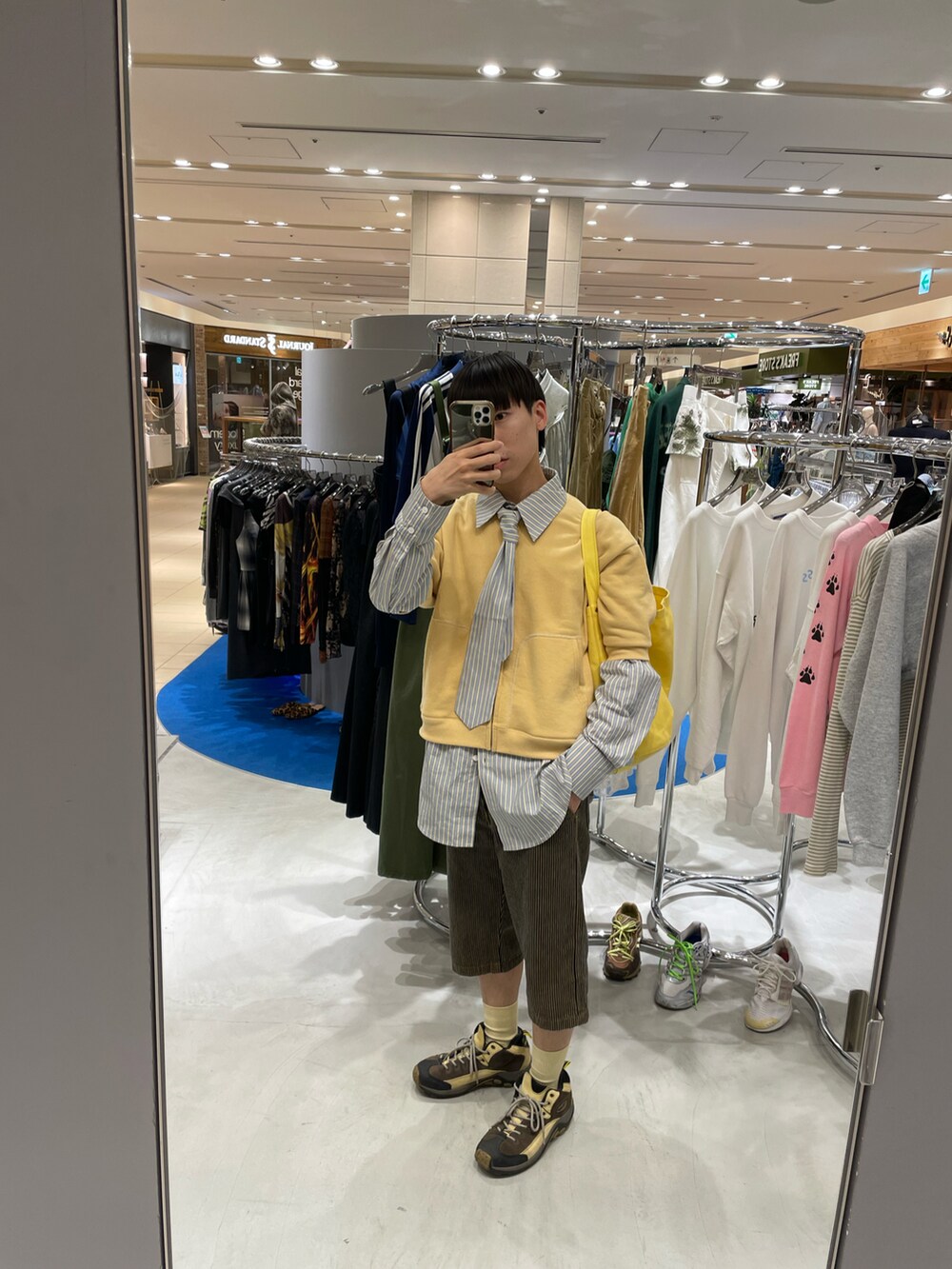 イエロー系のスウェット、ブルー系のシャツ/ブラウス、イエロー系のデニムパンツを着用したメンズの春コーディネートの2枚目の写真