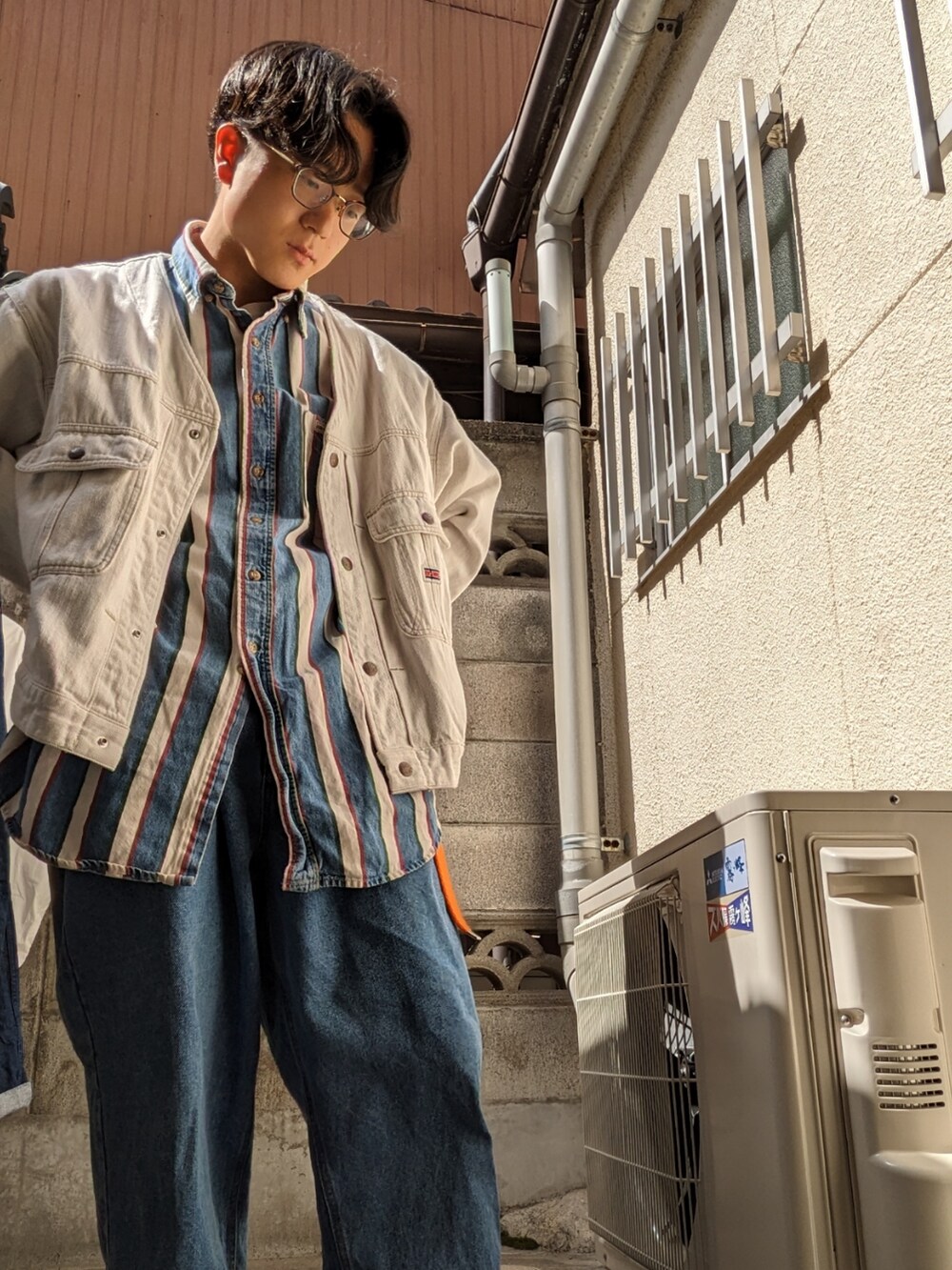 ブルー系のデニムパンツ、ホワイト系のスニーカー、ホワイト系のブルゾンを着用したメンズの春コーディネートの2枚目の写真