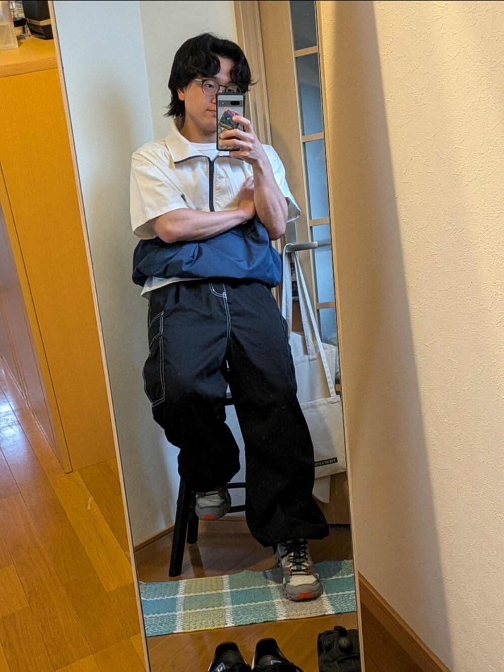 ブラック系のスニーカー、ブラック系のカーゴパンツ、ホワイト系のジャケット/アウターを着用したメンズの夏コーディネートの2枚目の写真