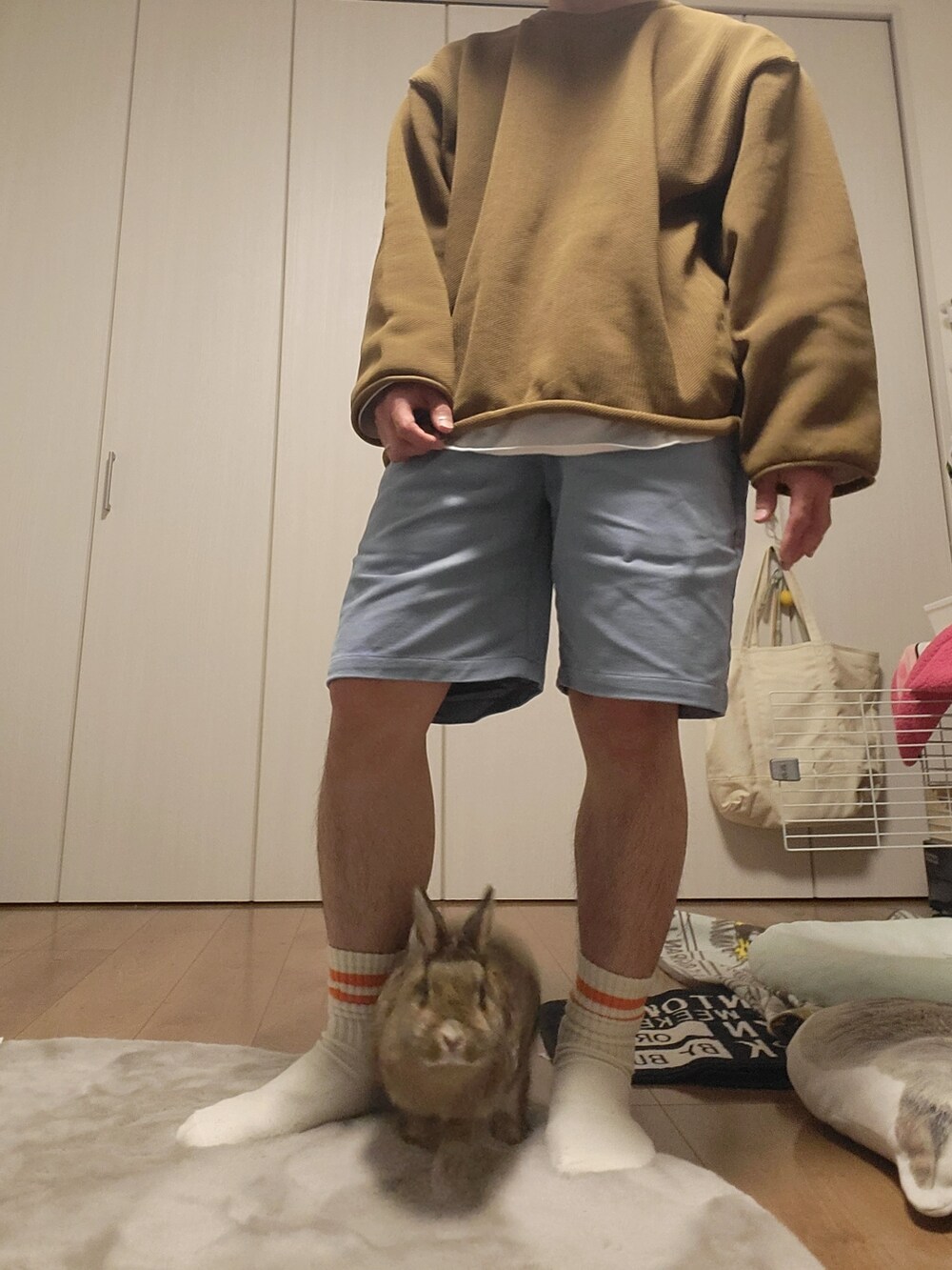 ベージュ系のニット/セーター、ブルー系のその他パンツ、ブラック系の帽子を着用したメンズの春コーディネートの3枚目の写真