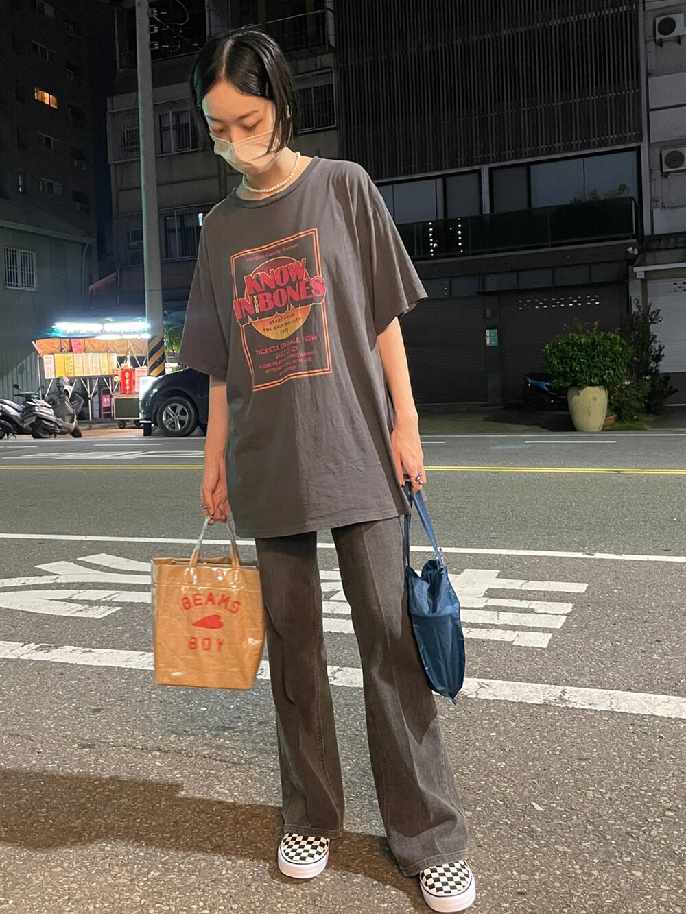 グレー系のTシャツ/カットソー、ブラウン系のデニムパンツ、ベージュ系のトートバッグを着用したレディースの秋コーディネートの2枚目の写真