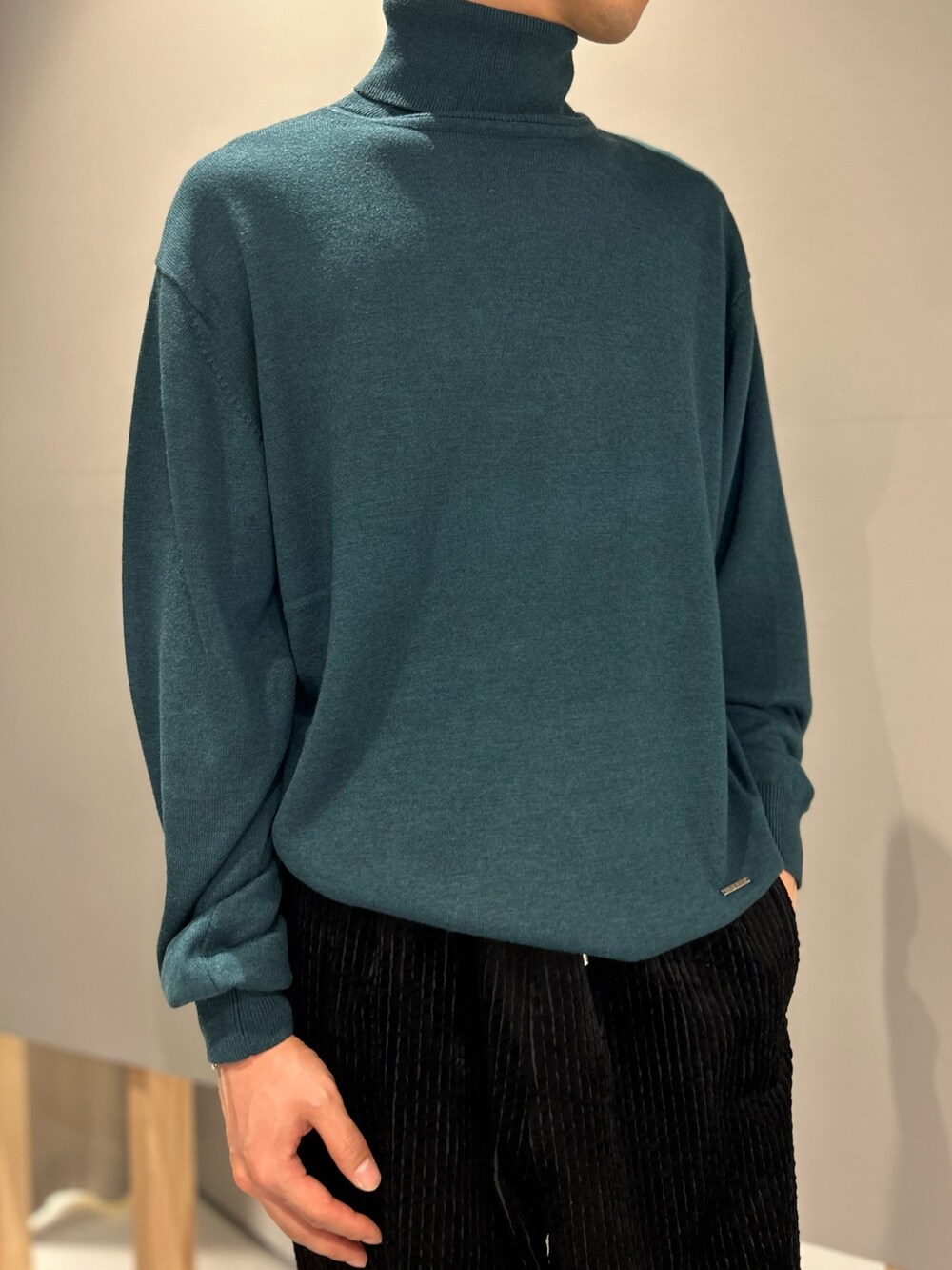 グリーン系のニット/セーター、ブラック系のその他パンツを着用したメンズの秋コーディネートの2枚目の写真