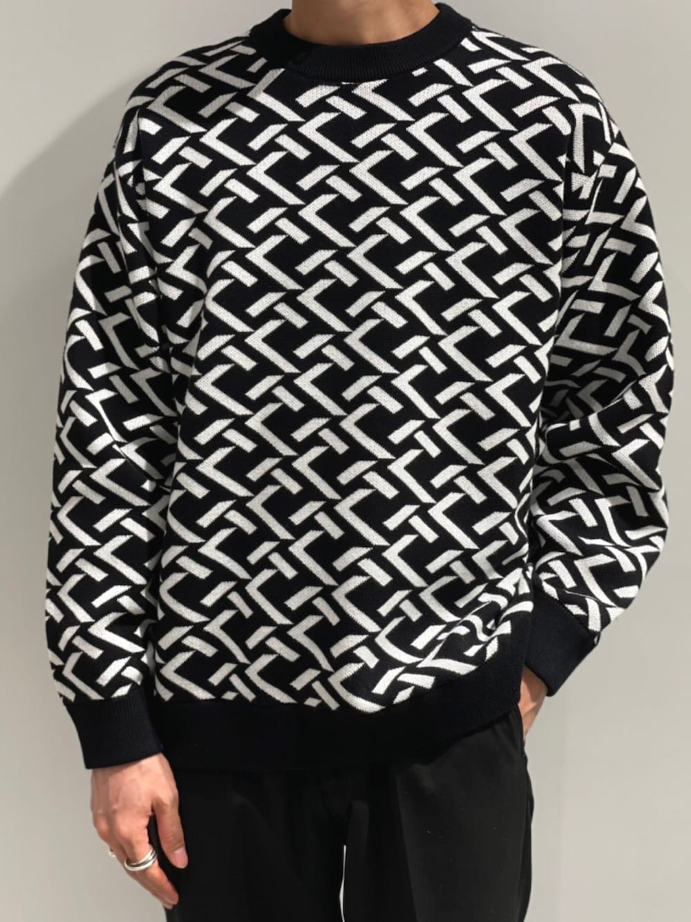 ブラック系のニット/セーター、ブラック系のドレスシューズ、ブラック系のスラックスを着用したメンズの秋コーディネートの2枚目の写真