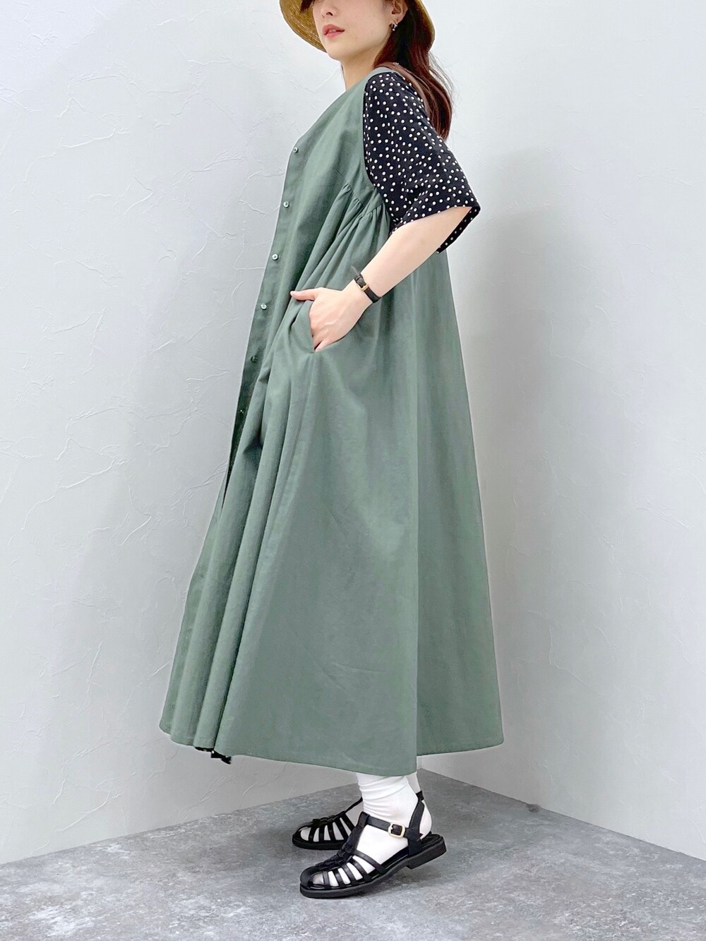 グリーン系のワンピース、ホワイト系のかごバッグ、ブラック系のサンダルを着用したレディースの春コーディネートの2枚目の写真