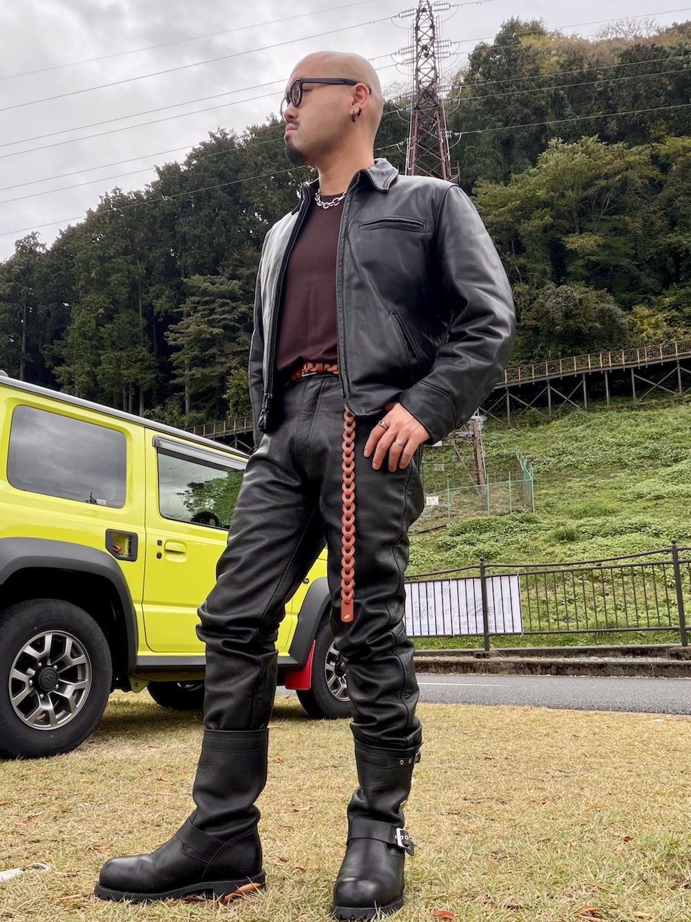 ブラック系のライダースジャケット、ブラウン系のTシャツ/カットソー、ブラック系のブーツを着用したメンズの秋コーディネートの2枚目の写真