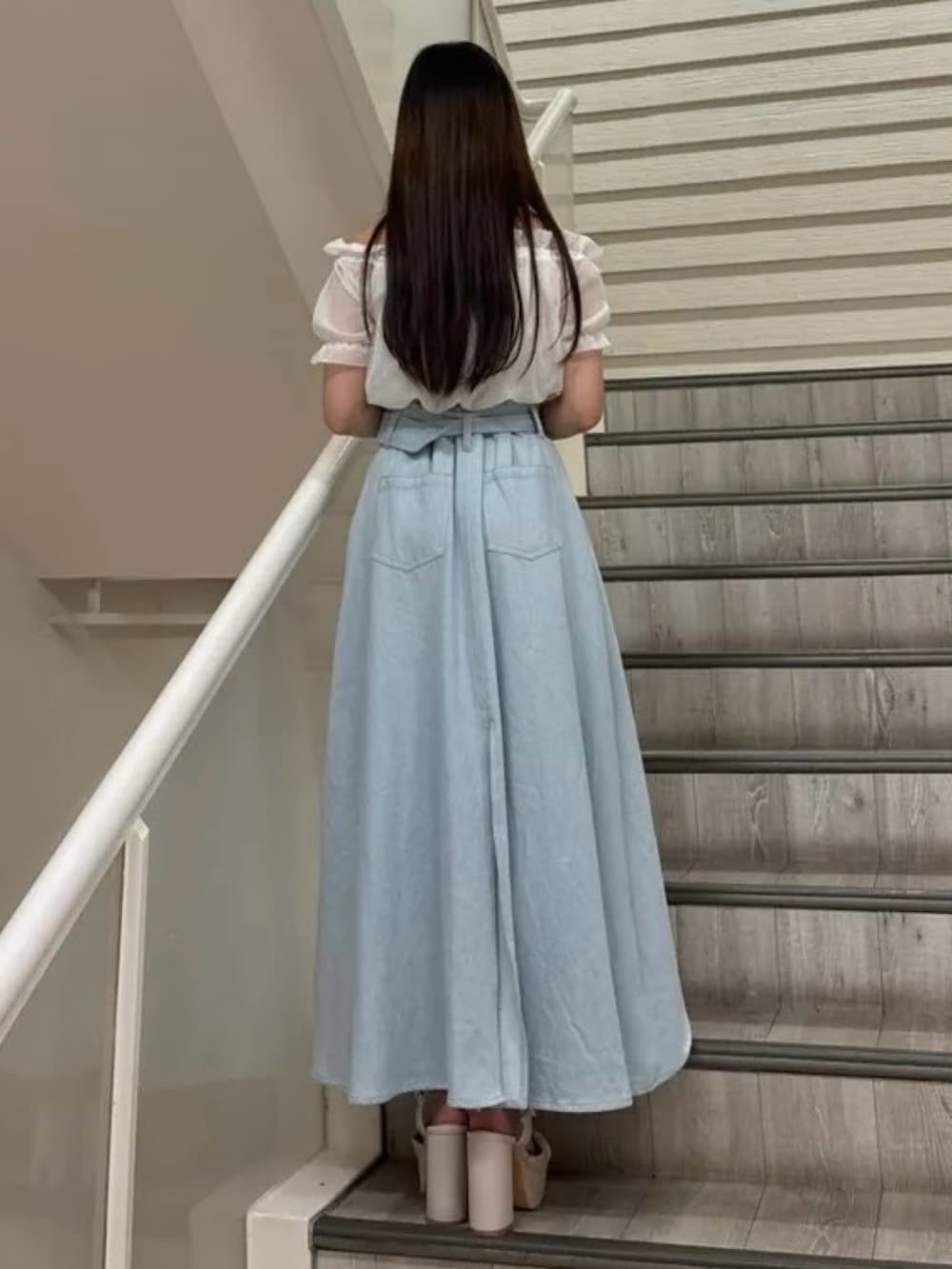 ベージュ系のサンダル、ブルー系のスカート、ホワイト系のシャツ/ブラウスを着用したレディースの春コーディネートの3枚目の写真
