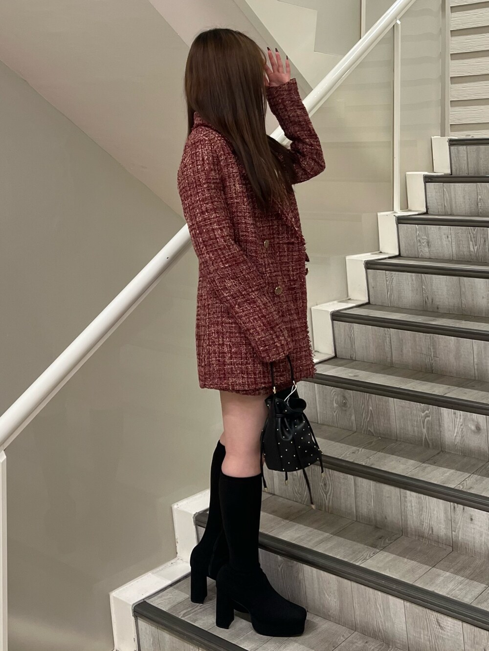 ブラック系のハンドバッグ、ブラック系のブーツ、ホワイト系のニット/セーターを着用したレディースの秋コーディネートの2枚目の写真