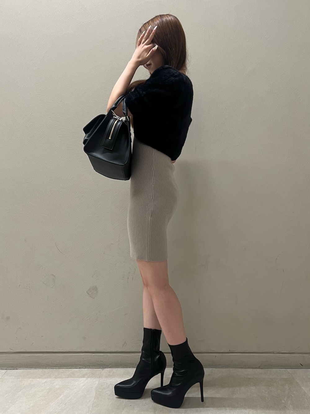 ブラック系のワンピース、ブラック系のブーツ、ブラック系のハンドバッグを着用したレディースの夏コーディネートの2枚目の写真