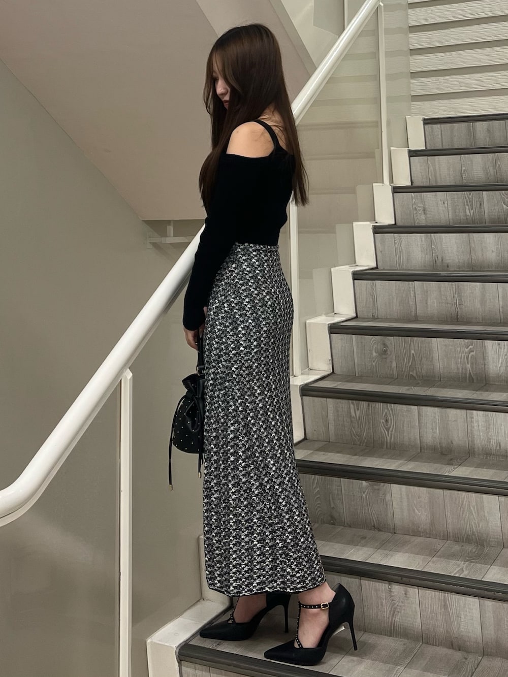 ブラック系のパンプス、ブラック系のハンドバッグ、ブラック系のワンピースを着用したレディースの秋コーディネートの2枚目の写真