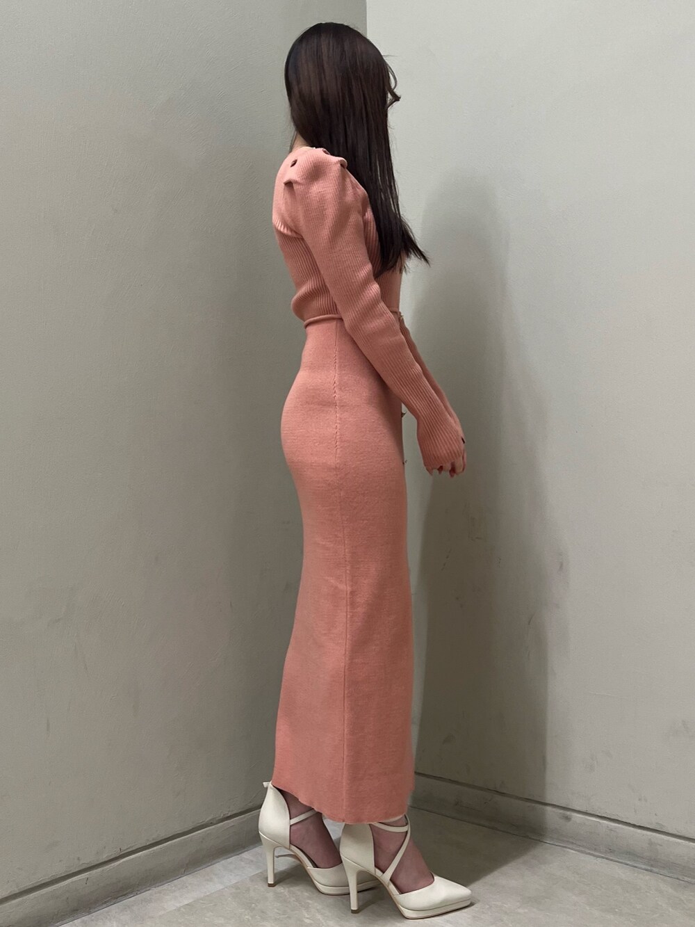 ホワイト系のパンプス、オレンジ系のワンピース、ゴールド系のネックレスを着用したレディースの冬コーディネートの2枚目の写真