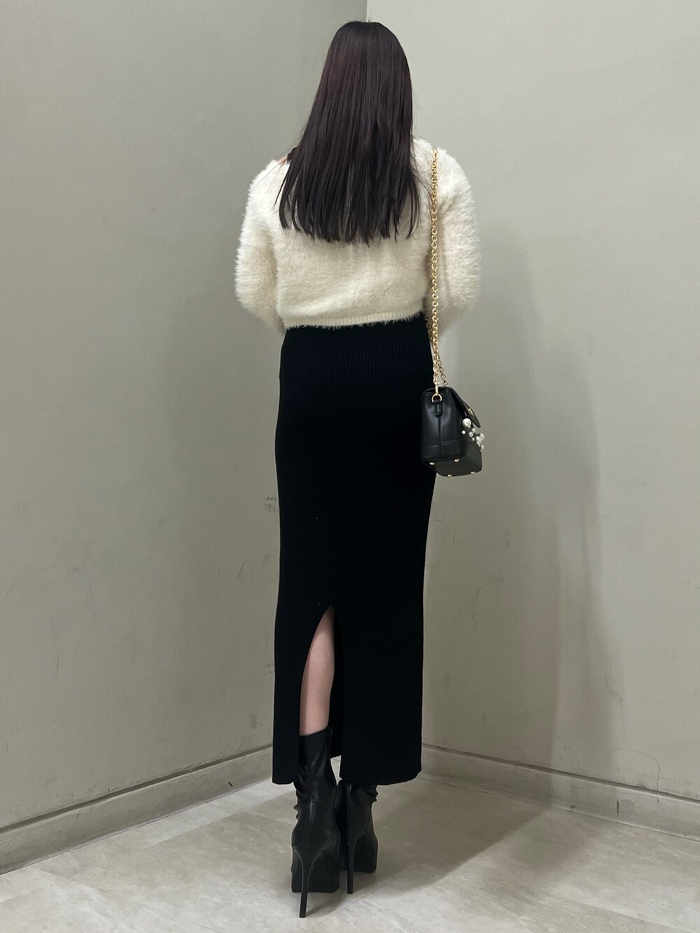 ブラック系のブーツ、ブラック系のショルダーバッグ、ブラック系のワンピースを着用したレディースの冬コーディネートの3枚目の写真