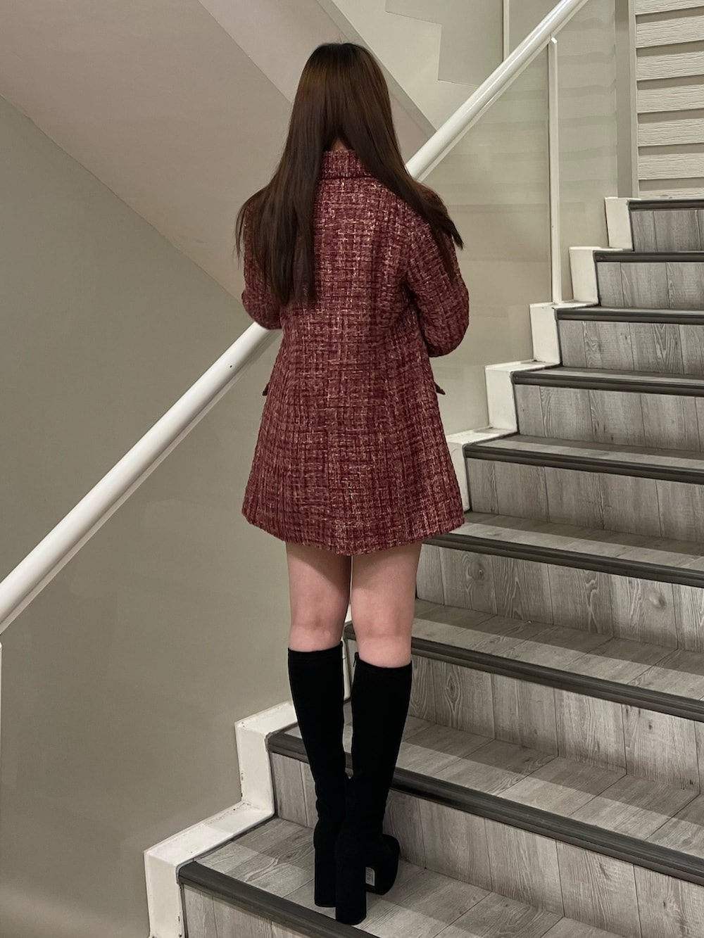 ブラック系のハンドバッグ、ブラック系のブーツ、ホワイト系のニット/セーターを着用したレディースの秋コーディネートの3枚目の写真