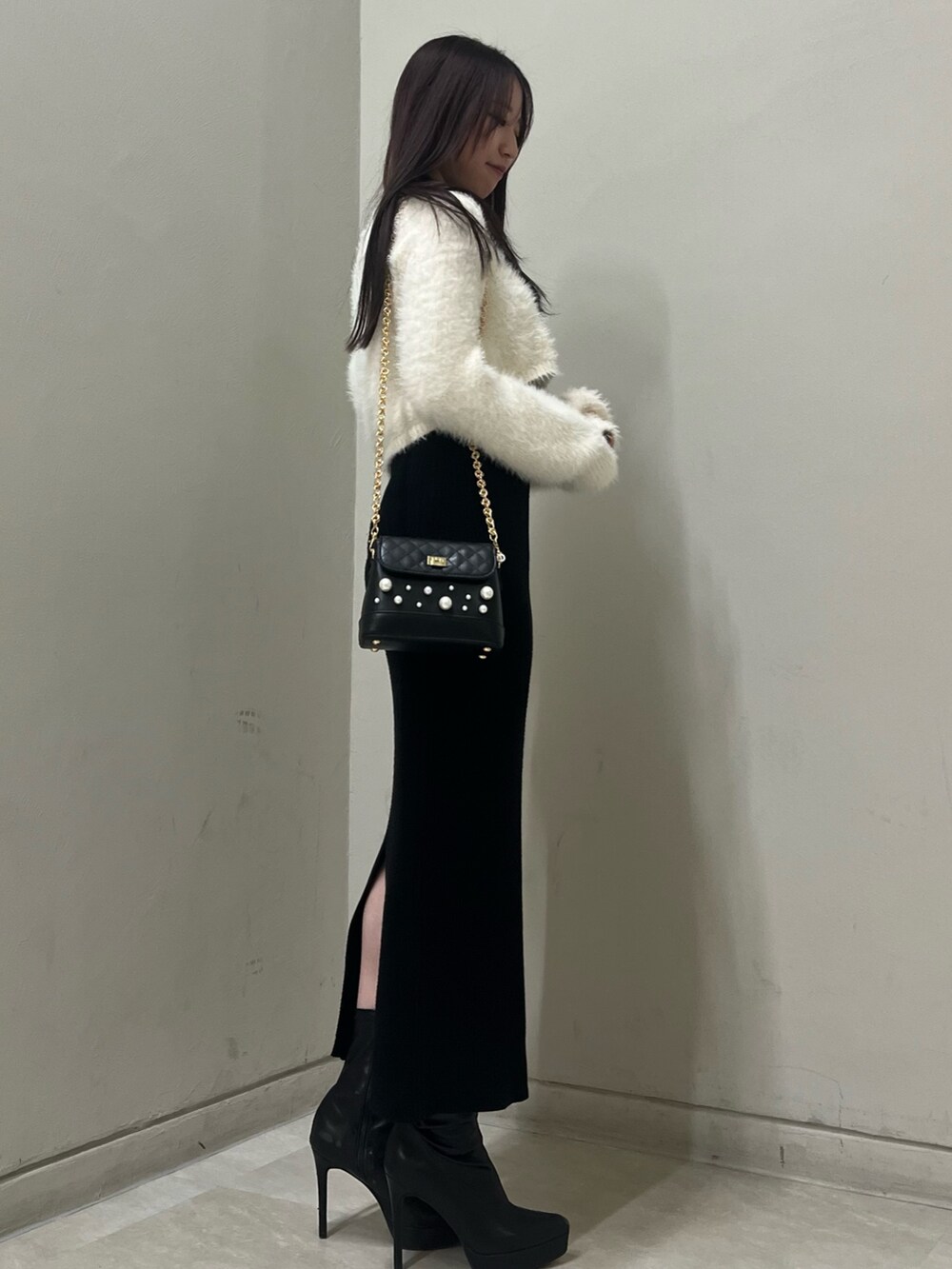 ブラック系のブーツ、ブラック系のショルダーバッグ、ブラック系のワンピースを着用したレディースの冬コーディネートの2枚目の写真