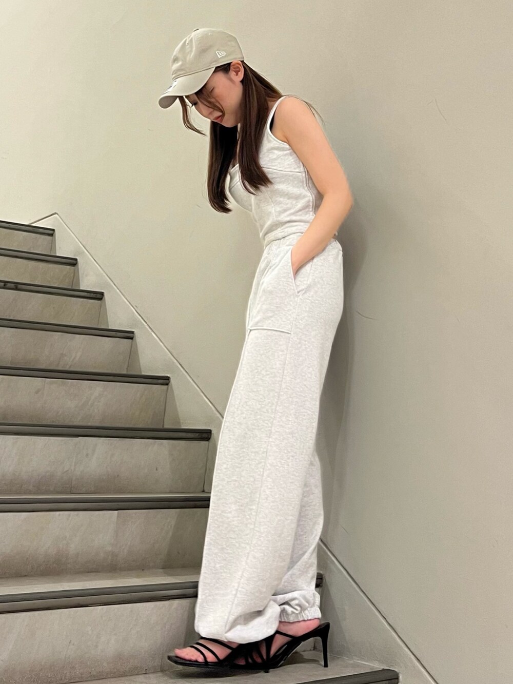 グレー系のタンクトップ、グレー系のスウェットパンツ、ブラック系のサンダルを着用したレディースの夏コーディネートの2枚目の写真