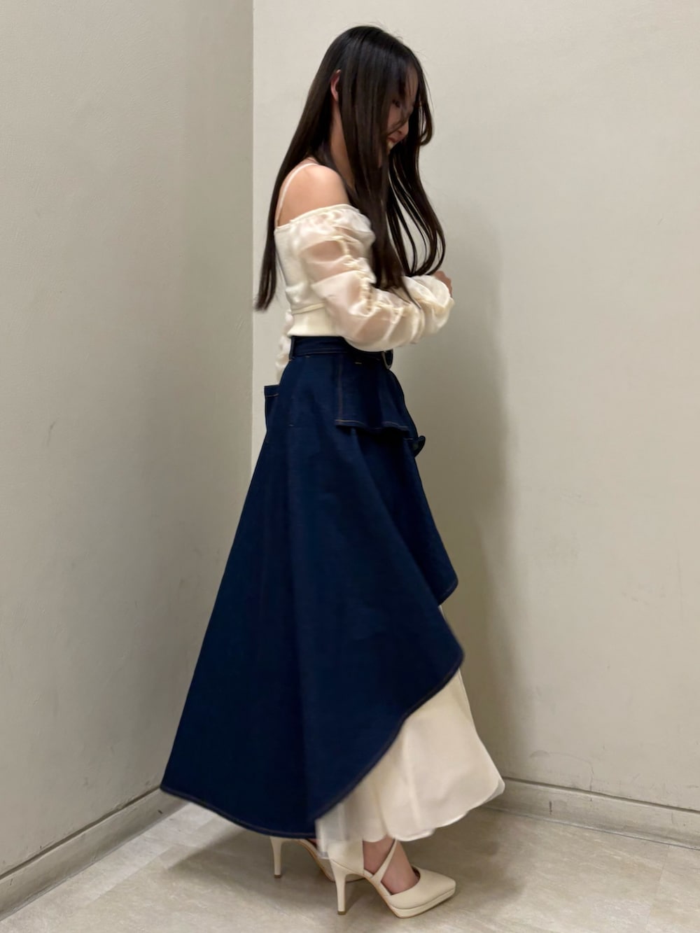 ホワイト系のニット/セーター、ホワイト系のパンプス、ブルー系のスカートを着用したレディースの春コーディネートの2枚目の写真