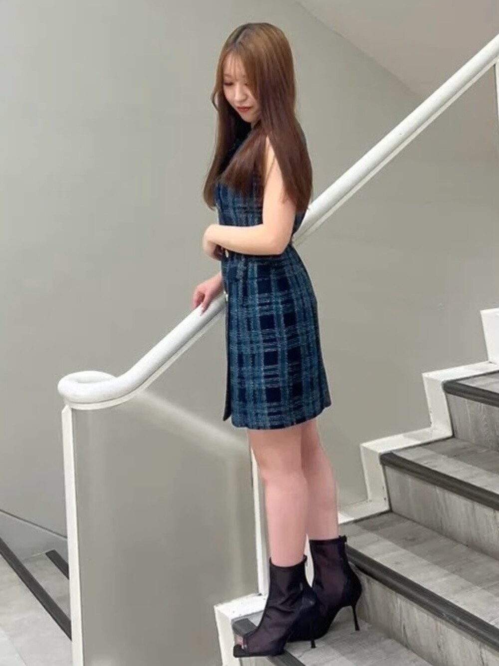 ブラック系のブーツ、ブラック系のショルダーバッグ、ブルー系のワンピースを着用したレディースの夏コーディネートの2枚目の写真