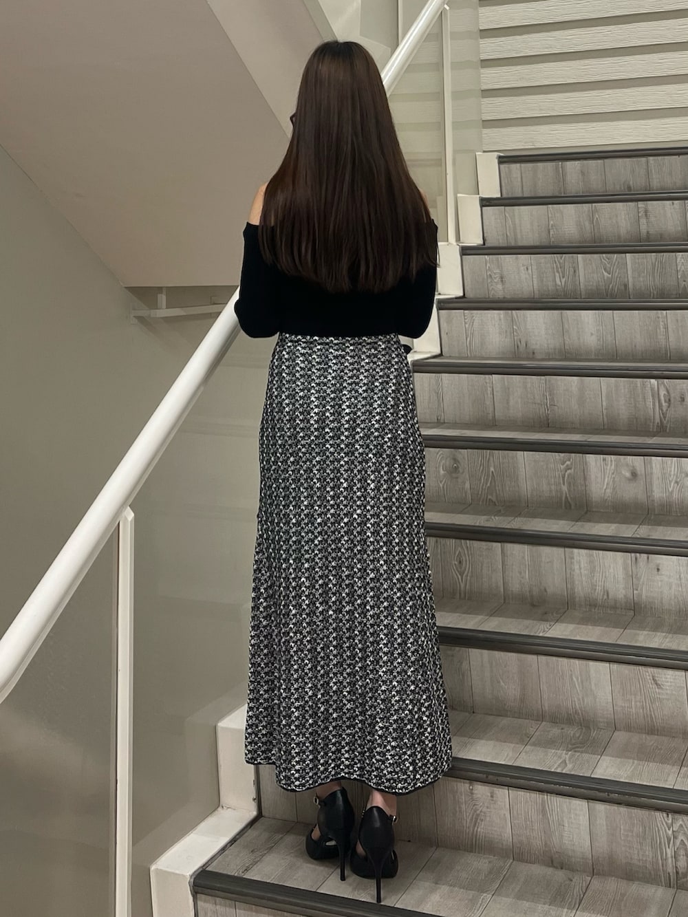 ブラック系のパンプス、ブラック系のハンドバッグ、ブラック系のワンピースを着用したレディースの秋コーディネートの3枚目の写真