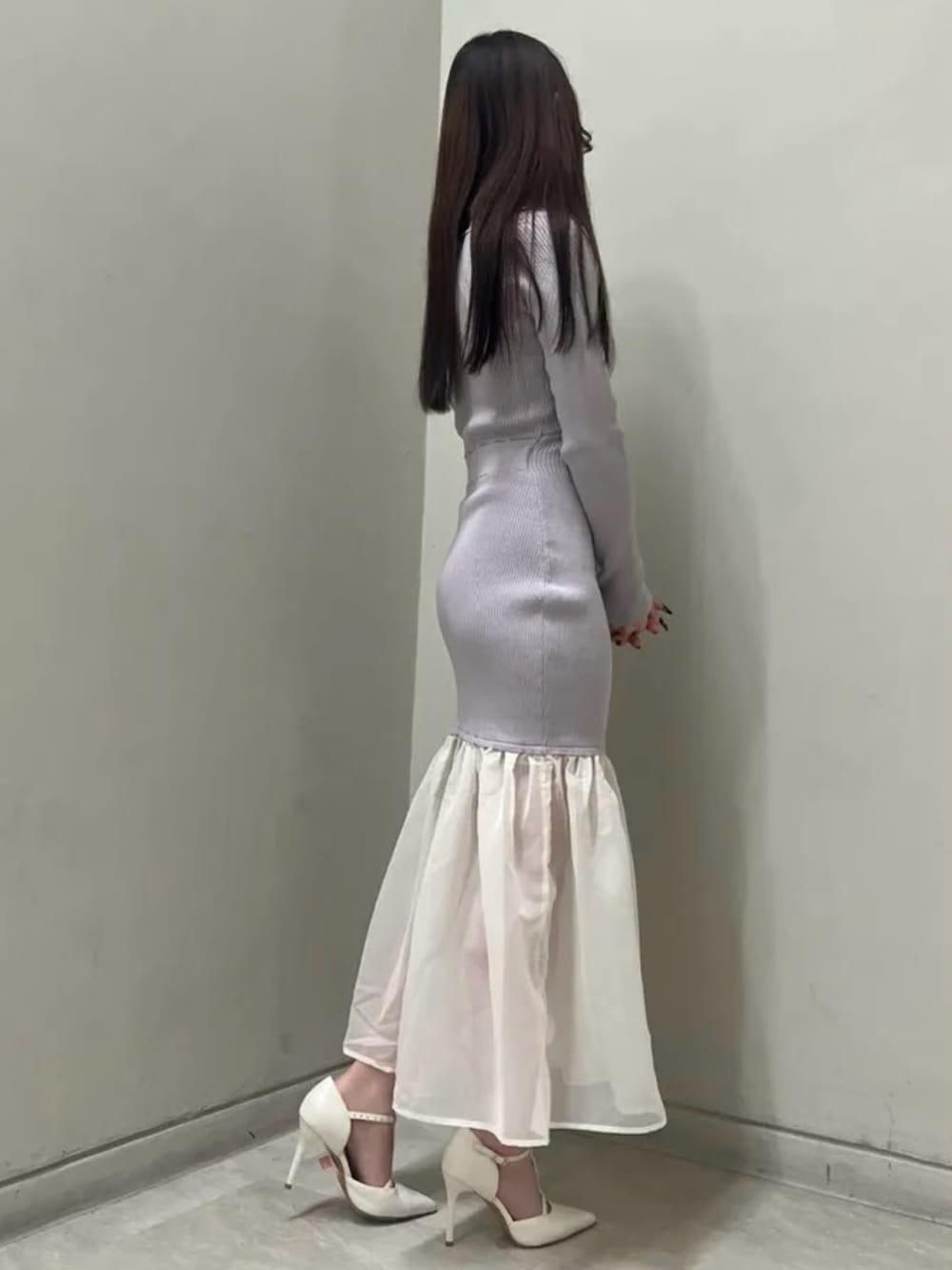 パープル系のワンピース、ホワイト系のパンプス、シルバー系のネックレスを着用したレディースの冬コーディネートの2枚目の写真