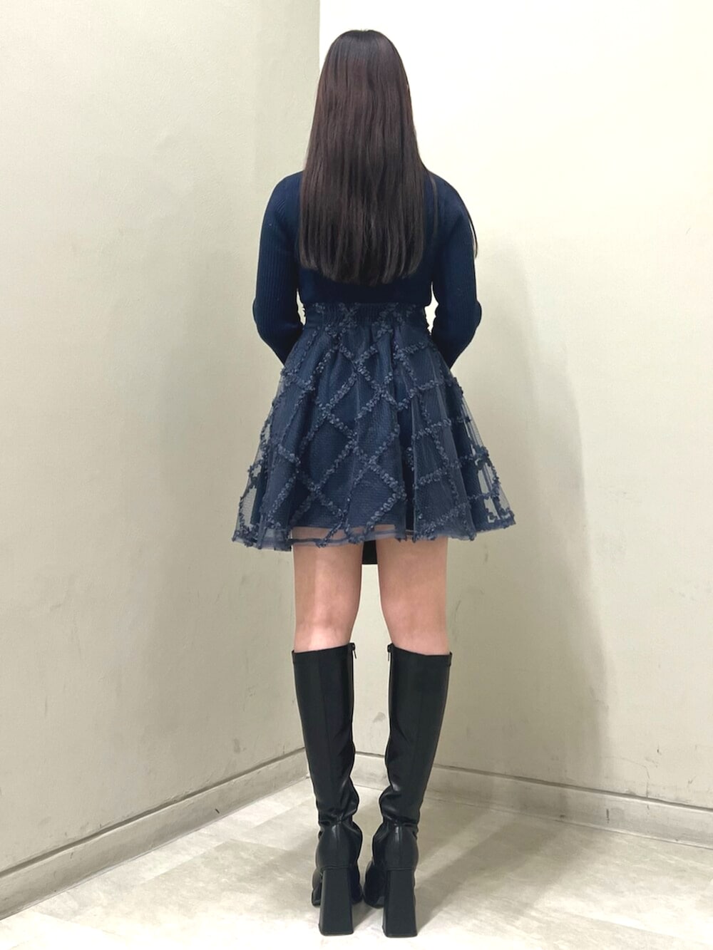 その他のハンドバッグ、ブラック系のブーツ、ブルー系のワンピースを着用したレディースの冬コーディネートの3枚目の写真