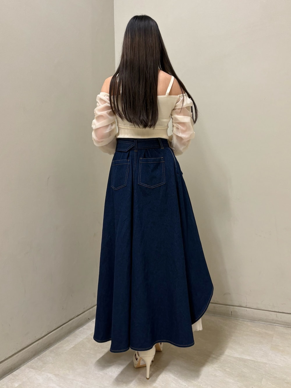 ホワイト系のニット/セーター、ホワイト系のパンプス、ブルー系のスカートを着用したレディースの春コーディネートの3枚目の写真