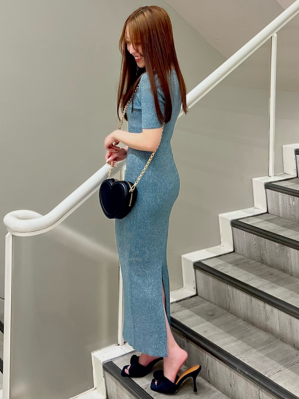 グリーン系のワンピース、ブラック系のサンダル、ブラック系のショルダーバッグを着用したレディースの夏コーディネートの2枚目の写真