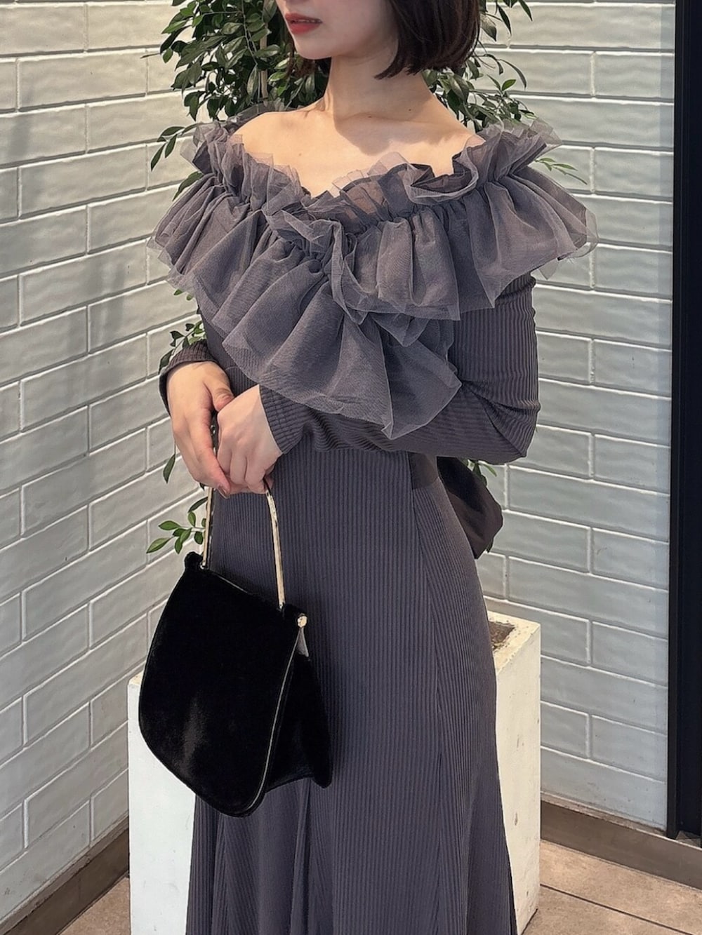 ブラック系のパンプス、グレー系のワンピース、ブラック系のハンドバッグを着用したレディースの秋コーディネートの6枚目の写真