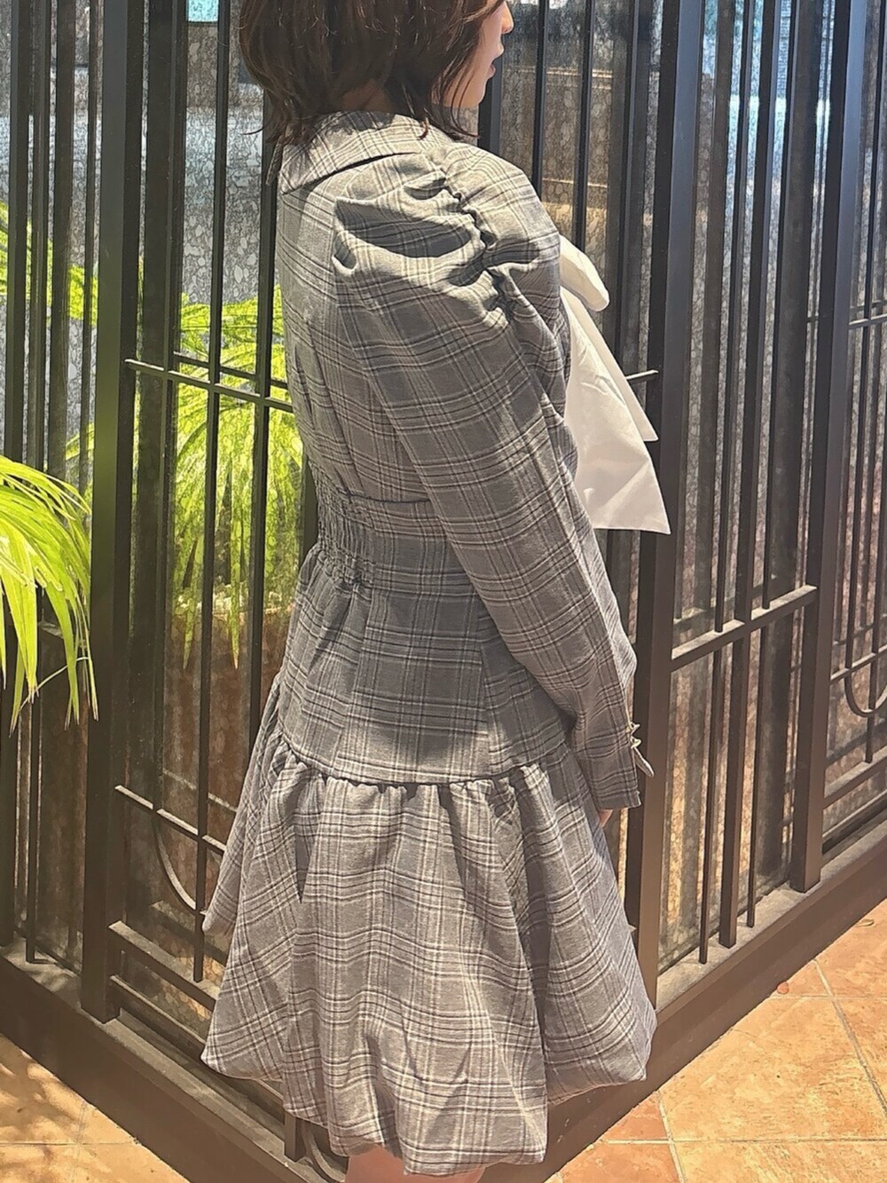 ブラウン系のブーツ、グレー系のワンピース、ホワイト系のブルゾンを着用したレディースの秋コーディネートの8枚目の写真