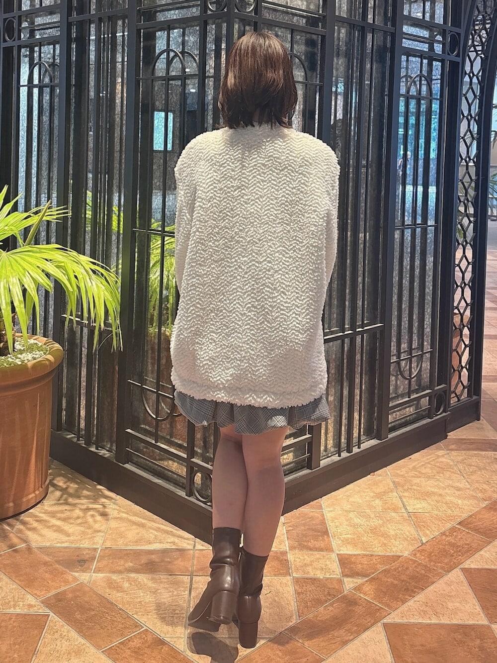 ブラウン系のブーツ、グレー系のワンピース、ホワイト系のブルゾンを着用したレディースの秋コーディネートの4枚目の写真