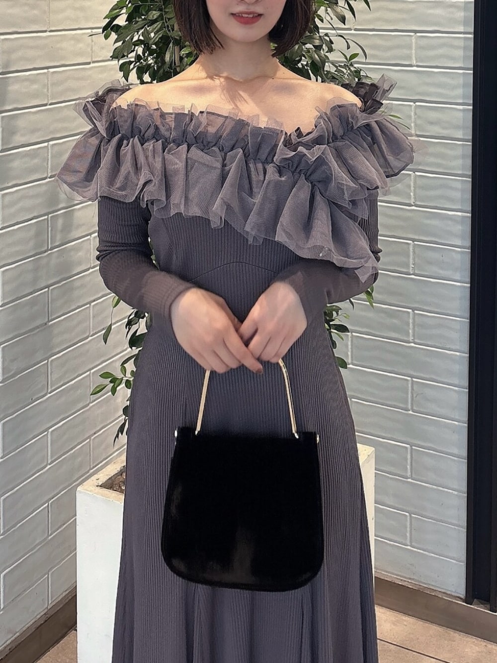 ブラック系のパンプス、グレー系のワンピース、ブラック系のハンドバッグを着用したレディースの秋コーディネートの5枚目の写真