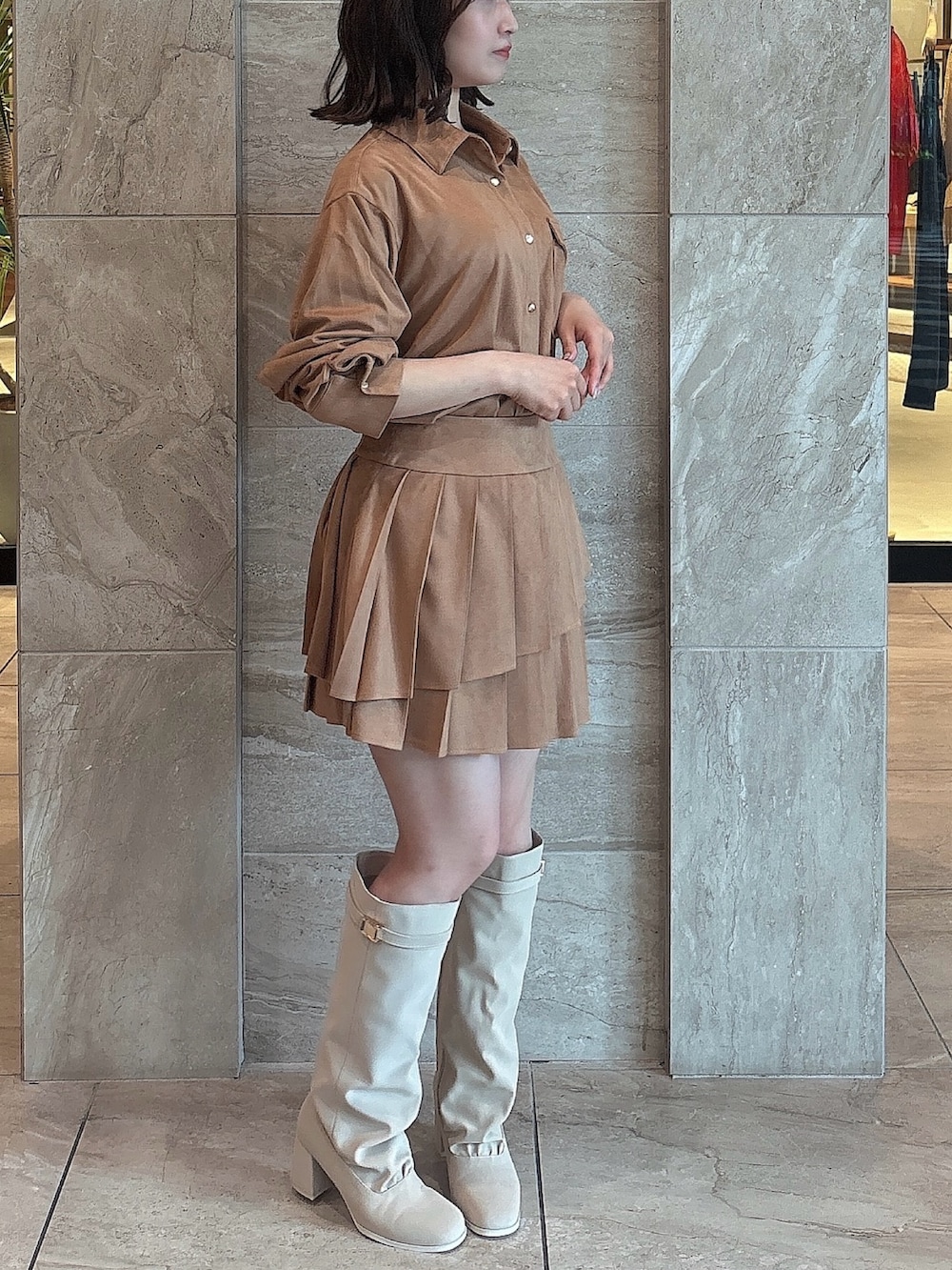 イエロー系のシャツ/ブラウス、イエロー系のスカート、ホワイト系のブーツを着用したレディースの夏コーディネートの3枚目の写真