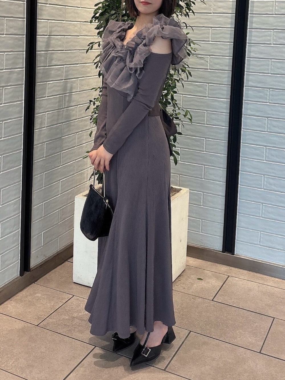 ブラック系のパンプス、グレー系のワンピース、ブラック系のハンドバッグを着用したレディースの秋コーディネートの3枚目の写真