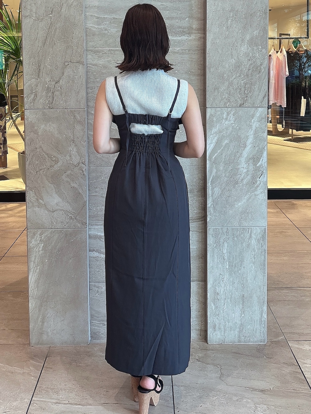 グレー系のワンピース、ブラック系のサンダル、ホワイト系のニット/セーターを着用したレディースの夏コーディネートの3枚目の写真