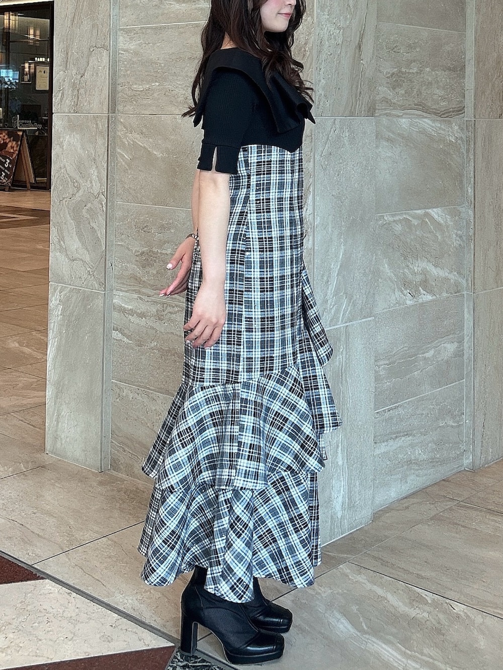 ブラック系のワンピース、ブラック系のブーツを着用したレディースの春コーディネートの3枚目の写真