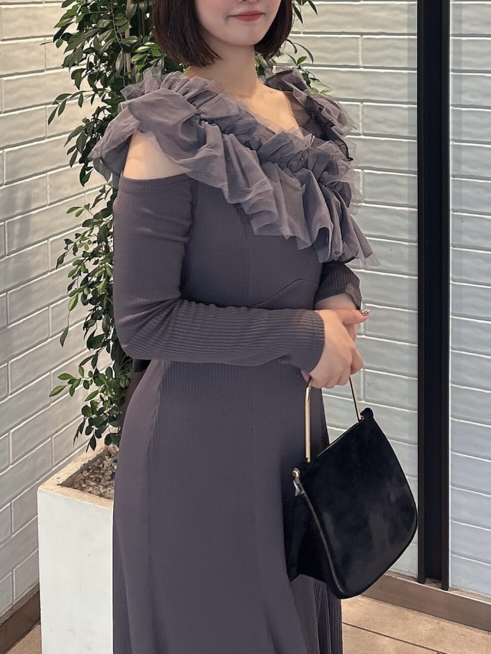 ブラック系のパンプス、グレー系のワンピース、ブラック系のハンドバッグを着用したレディースの秋コーディネートの7枚目の写真