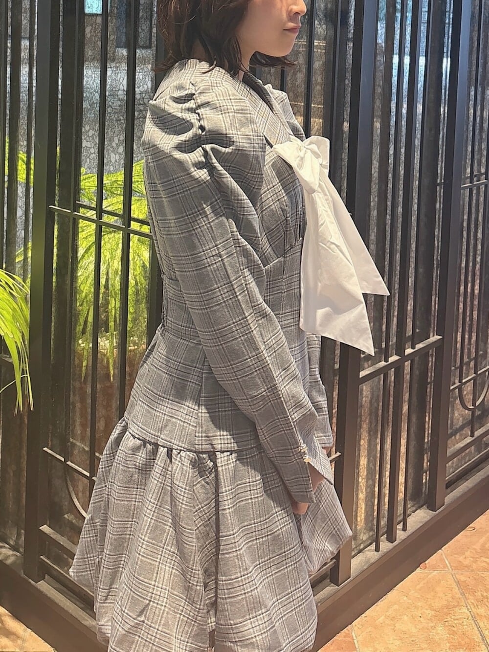 ブラウン系のブーツ、グレー系のワンピース、ホワイト系のブルゾンを着用したレディースの秋コーディネートの7枚目の写真