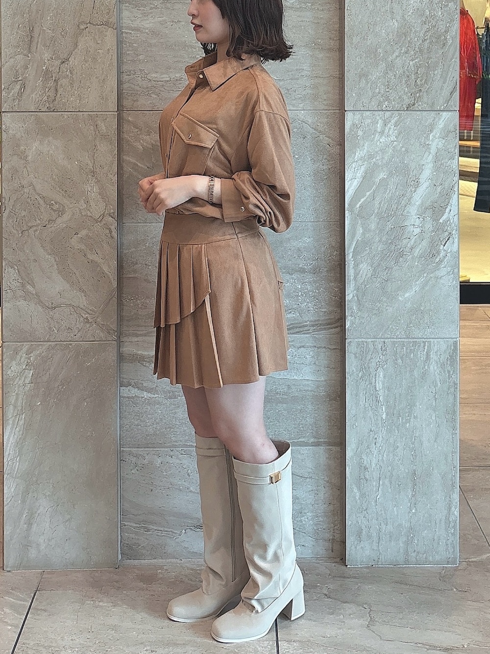 イエロー系のシャツ/ブラウス、イエロー系のスカート、ホワイト系のブーツを着用したレディースの夏コーディネートの2枚目の写真