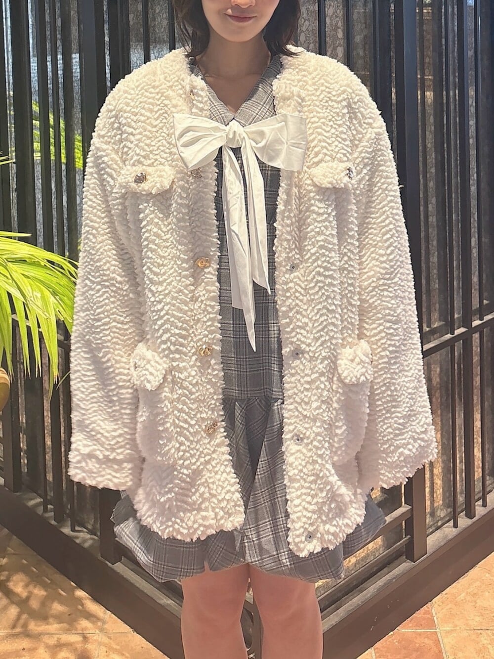 ブラウン系のブーツ、グレー系のワンピース、ホワイト系のブルゾンを着用したレディースの秋コーディネートの5枚目の写真