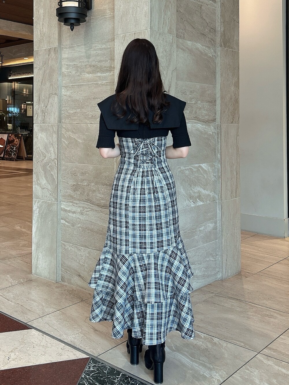 ブラック系のワンピース、ブラック系のブーツを着用したレディースの春コーディネートの4枚目の写真