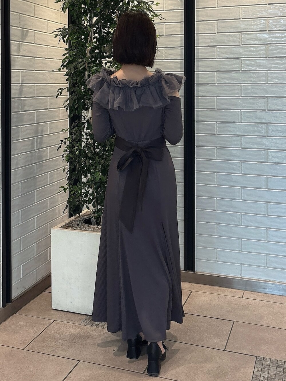 ブラック系のパンプス、グレー系のワンピース、ブラック系のハンドバッグを着用したレディースの秋コーディネートの4枚目の写真