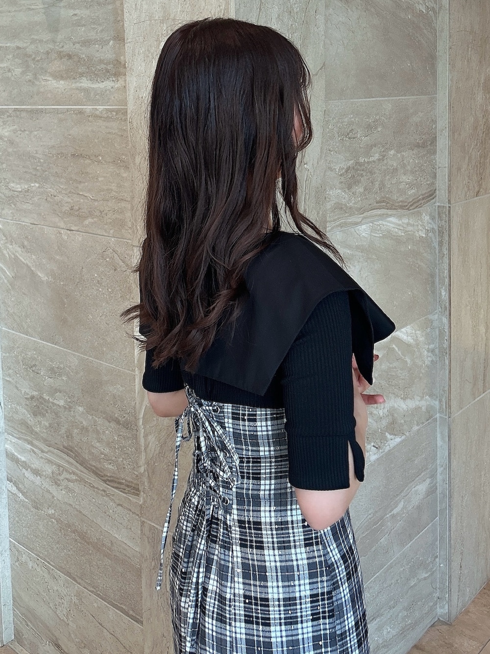 ブラック系のワンピース、ブラック系のブーツを着用したレディースの春コーディネートの6枚目の写真