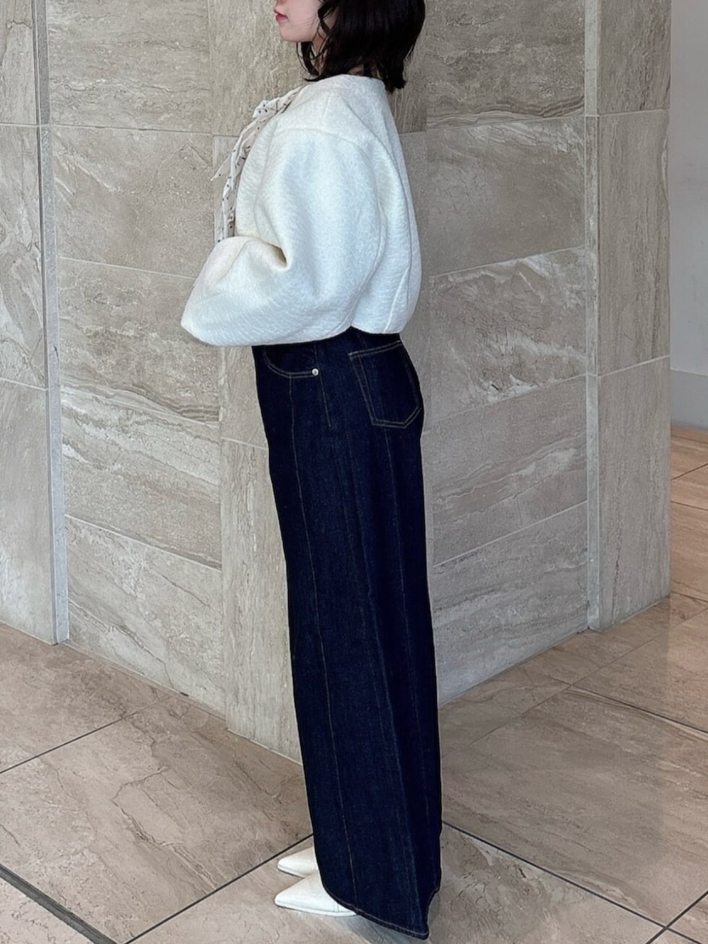 ホワイト系のパンプス、ブルー系のデニムパンツ、ホワイト系のブルゾンを着用したレディースの冬コーディネートの3枚目の写真