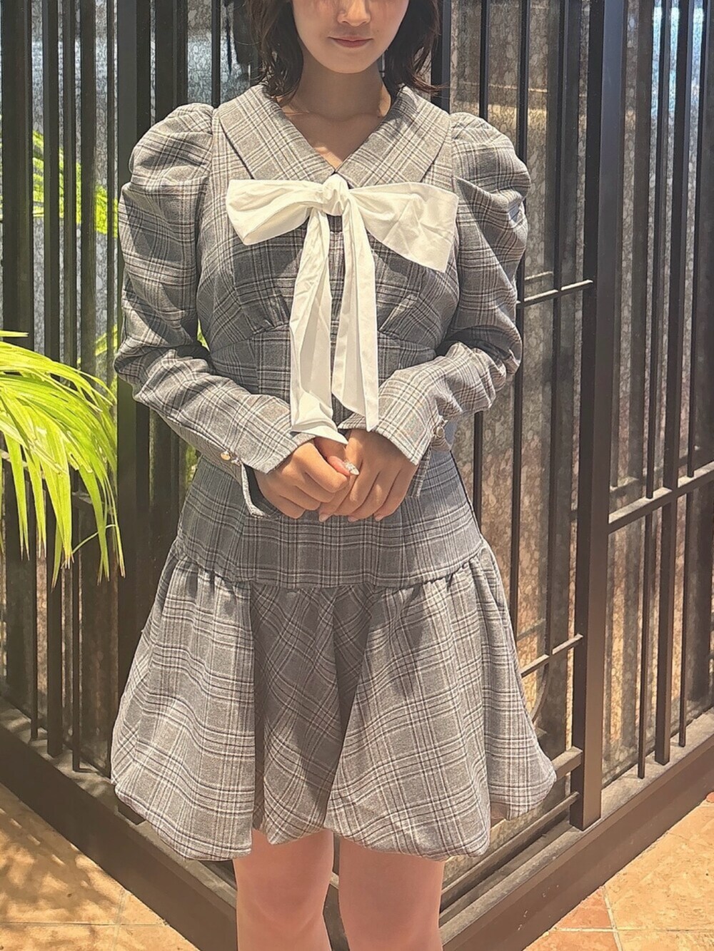 ブラウン系のブーツ、グレー系のワンピース、ホワイト系のブルゾンを着用したレディースの秋コーディネートの6枚目の写真