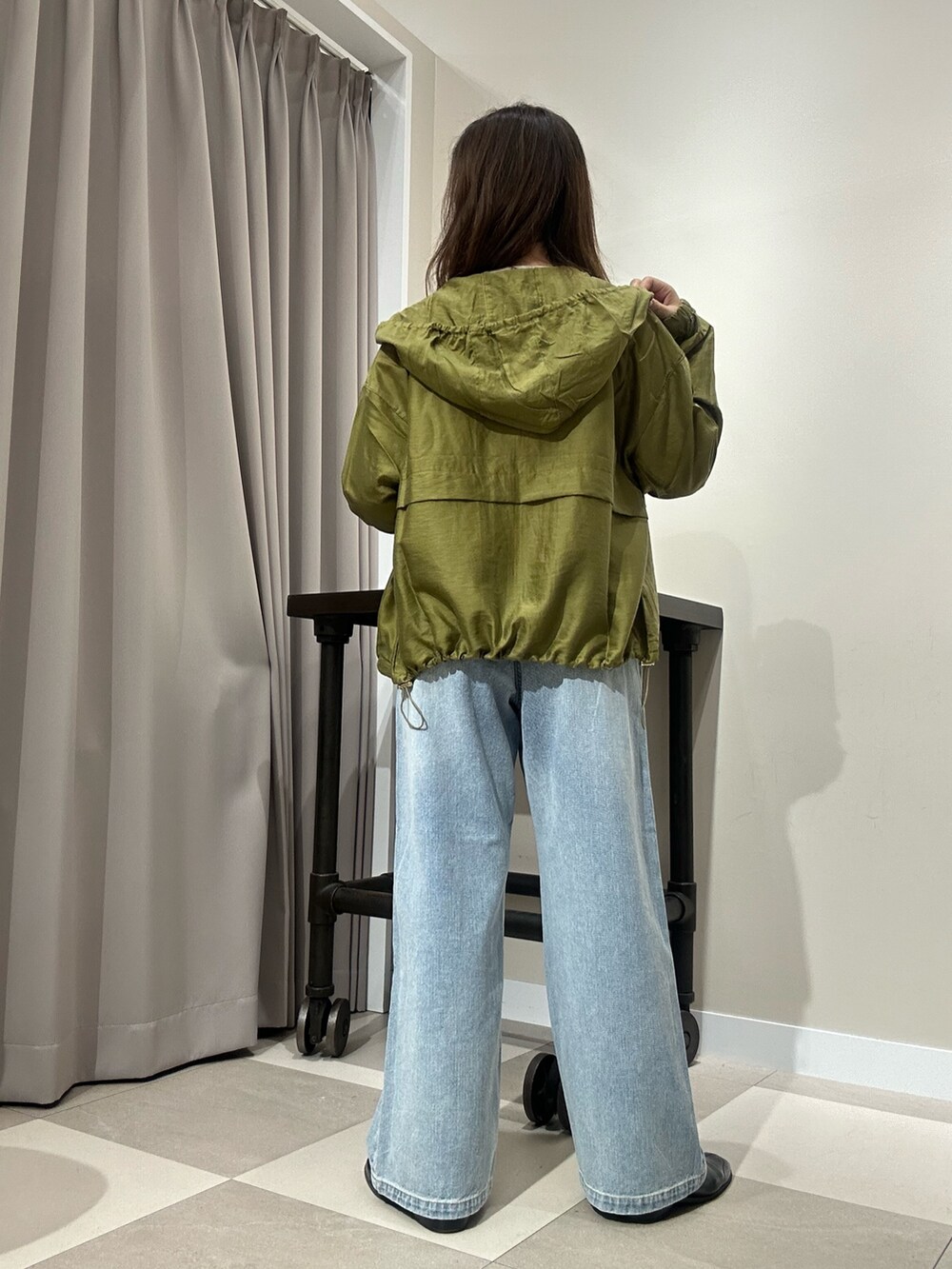 ブルー系のデニムパンツ、ホワイト系のニット/セーター、グリーン系のブルゾンを着用したレディースの秋コーディネートの3枚目の写真