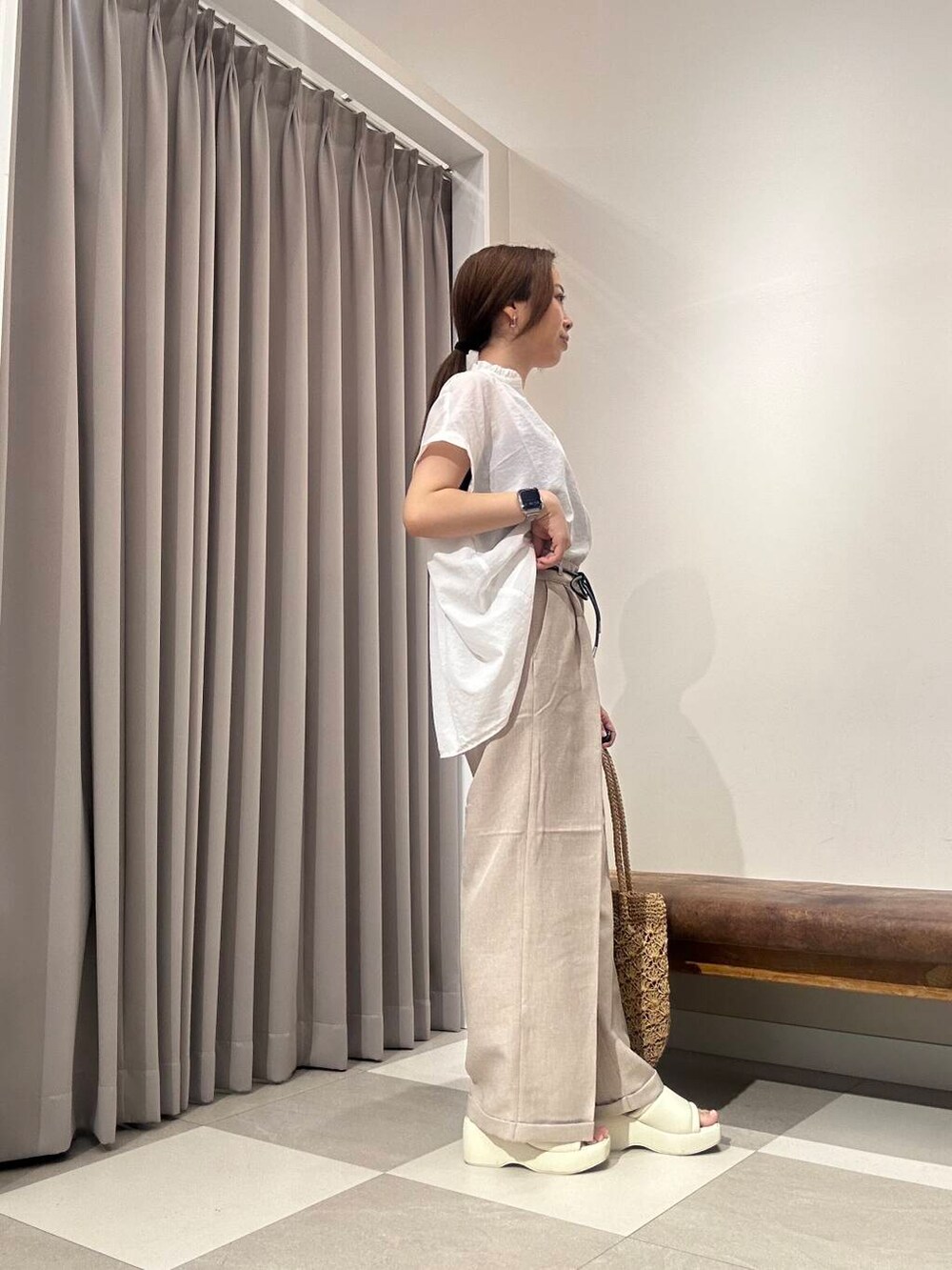 ベージュ系のトートバッグ、ブラック系のタンクトップ、ベージュ系のその他パンツを着用したレディースの夏コーディネートの2枚目の写真